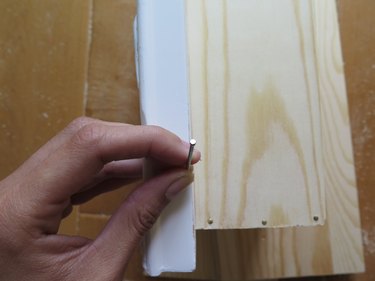 Nail the frame to the wooden box.