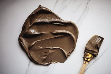 Use the rubber spatula to mix the food dyes together to form a  cool cappuccino brown color.