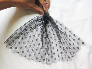 Scrunching the top of the lace veil together.