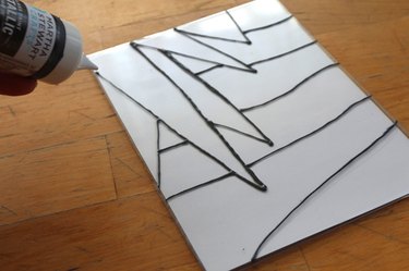 An acrylic picture frame with a painted design on top