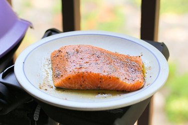 Salmon on a plate next to a grill