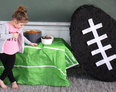 little girl next to giant football pinata