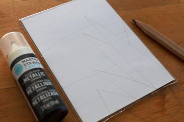 An acrylic picture frame, pencil and bottle of paint