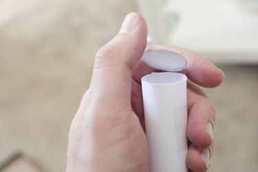Tape the paper circles to the ends of the cylinder