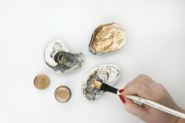Applying paint to inside of oyster shells