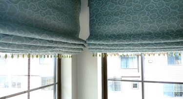 Green Roman shades drawn up.