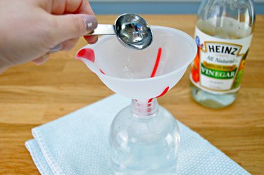 Adding vinegar to spray bottle