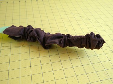 The tail scrunched on the end of a wooden spoon.