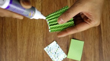 Applying glue to scrapbook paper to make Christmas tree.