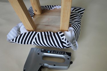 Staple the fabric to the stool.