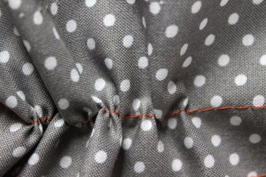 Pull on the bottom thread to gather the fabric.
