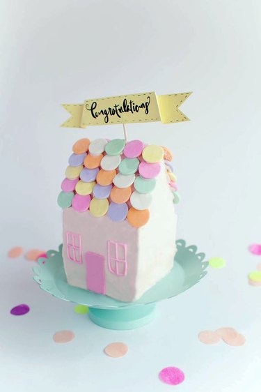 Finished cake-shaped house with "Congratulations" cake topper