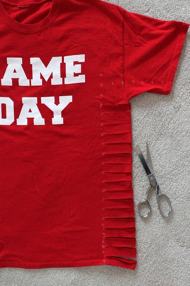 cutting slits along the sides of the shirt
