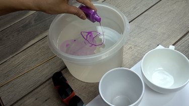 Pouring nail polish in warm water for nail polish marbled mugs.