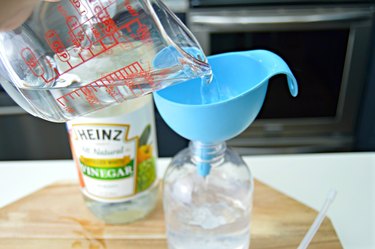 pouring vinegar into a spray bottle