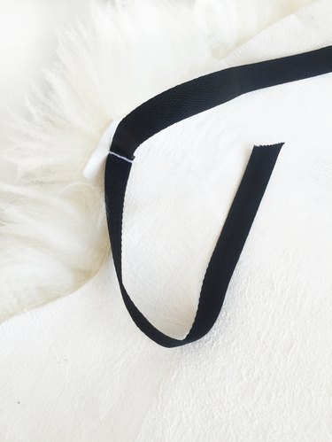 Attach twill tape to sheep skin.