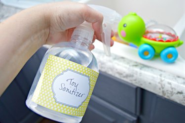 Cleaning baby toys with disinfectant spray