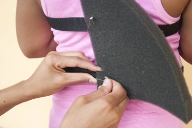 Pinning a foam shark fin to cloth belts before sewing