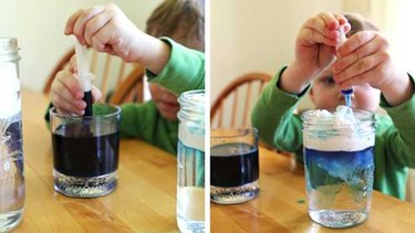 Child adding coloring to shaving cream cloud