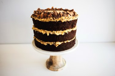 German chocolate cake layers assembled on a cake stand.