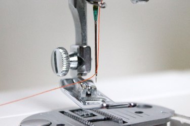 Thread the needle from the front to the back.