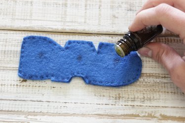 Drops of essential oil placed in 3 places along "DAD" design, one on each letter.