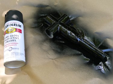 A can of black spray paint and the painted handle unit.