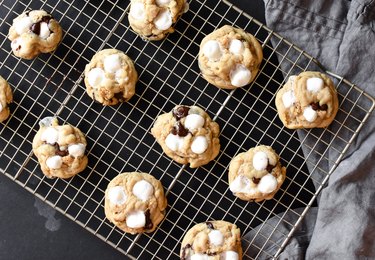 A dozen s'mores cookies cooling on a rack