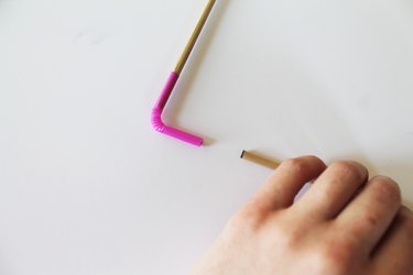 Insert the dowels into the straws.
