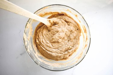 Folding together the liquid and dry ingredients to form a smooth batter.