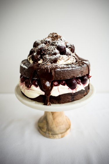 A Black Forest Cake on a cake stand, ready to serve.