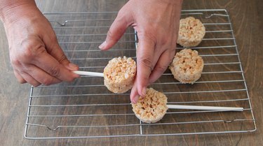 Pressing lollipop stick into Krispies.