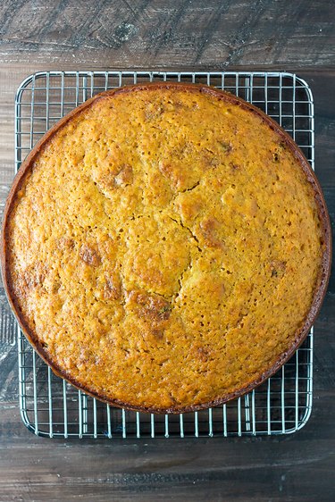 Baked cake being cooled on a wire rack.