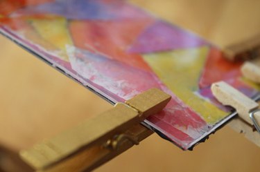 Clothespins holding a melted crayon project together while the glue sets- rear view