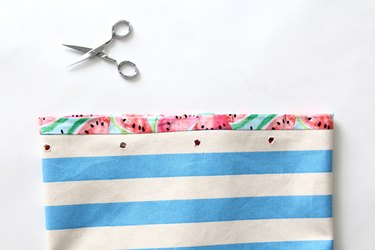 cut holes in fabric prior to setting grommets