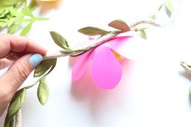 Apply hot glue to the back of the flower and attach.