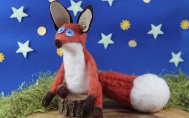 Needle felted fox on a wood log