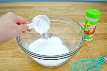 Pouring citric acid into a bowl for toilet cleaning tablets
