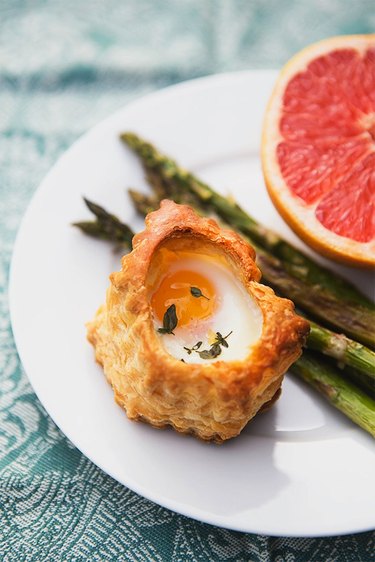 Plate of the pastry baked egg, asparagus and half of a grapefruit.