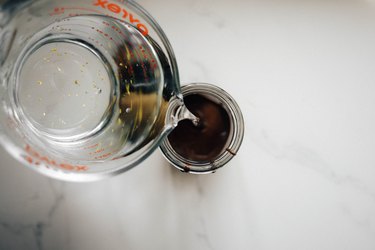 Pouring the vodka into the glass jar with the chocolate