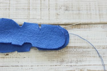 "DAD" design felt pieces, one on top of the other, with needle going through top piece, from underside of top piece.