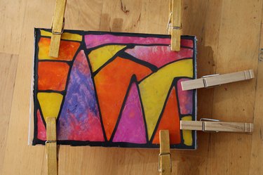 Clothespins holding a melted crayon project together while the glue sets- front view