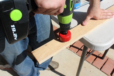Using a hole saw to create holes for boiler drain.