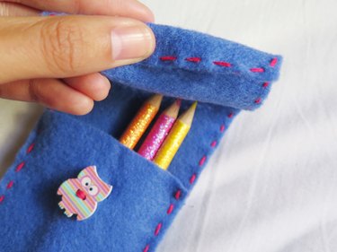 Folding the flap horizontally to cut a vertical slit on the DIY felt pencil case