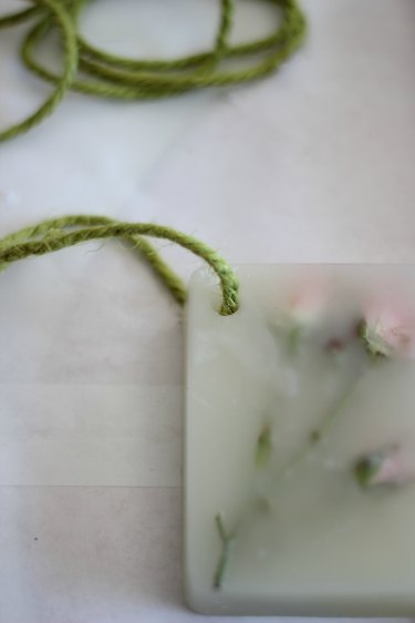 Thread jute twine through hole and tie.