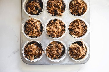 Adding the streusel to the muffins before baking.