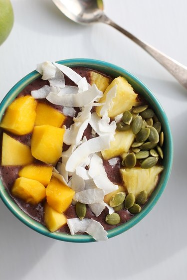 Acai bowl with mango, pineapple, coconut and pumpkin seeds