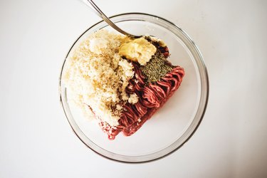 Beef hamburger patty ingredients in a large bowl.