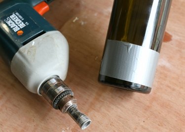 Applying duct tape to a wine bottle