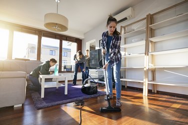Family cleaning the living room after party